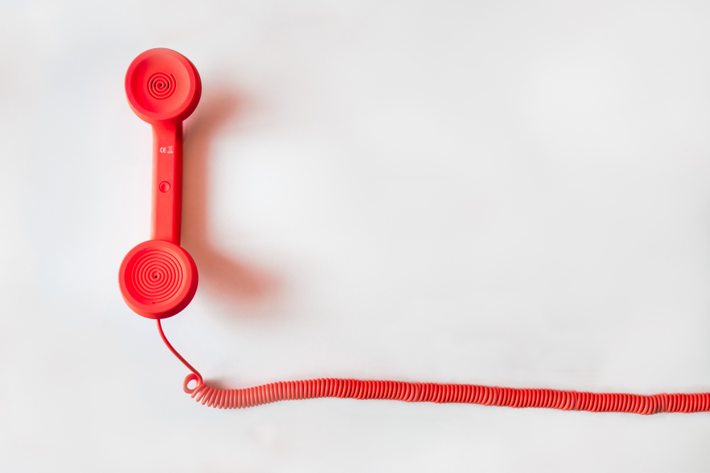 red vintage telephone reciever on a white background
